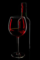 Red wine bottle and glass  silhouette isolated on a black background. 