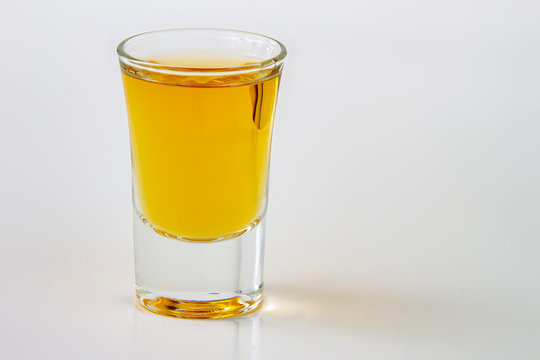 A horizontal view of a liquor shot drink on a white background