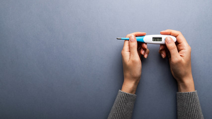 Measuring body temperature with a thermometer. Concept with sick person having fever heat, cold,...