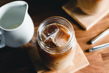 Top view of a glass jar with iced latte on a table