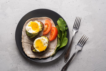 Sandwich with guacamole made of ripe avocados and poached egg. Healthy diet or vegetarian food  