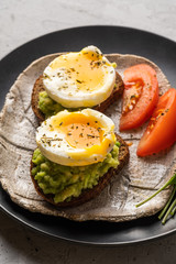 Sandwich with guacamole made of ripe avocados and poached egg. Healthy diet or vegetarian food  