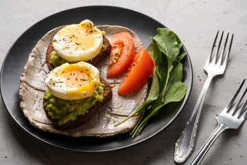 Sandwich with guacamole made of ripe avocados and poached egg. Healthy diet or vegetarian food  