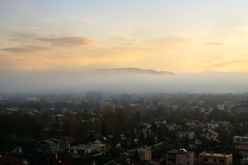 Sunrise and sunset, beautiful clouds over the meadow, hills and buildings in the town. Slovakia