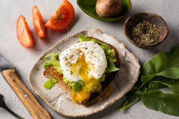 Sandwich with guacamole made of ripe avocados and poached egg. Healthy diet or vegetarian food  
