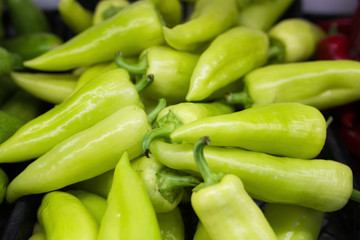 A bunch of green bell peppers in a store