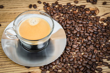 Cup of coffee and coffee beans on wooden  background.
