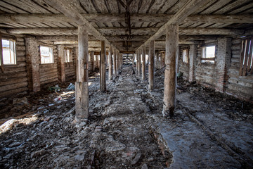 Fototapeta na wymiar Abandoned ruined barn cowshed inside view 