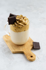 Dalgona coffee with chocolate on a wooden board.