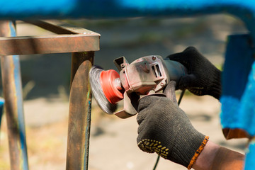 Hand with a turbine removes rust from metal