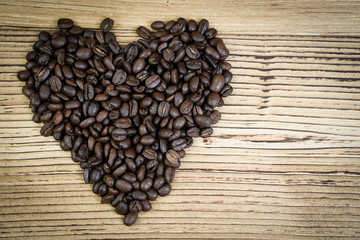 Fresh coffee beans on  wooden table background.