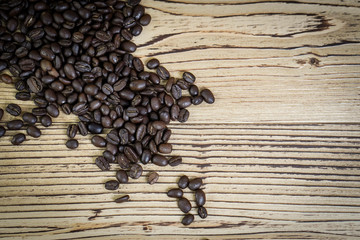 Fresh coffee beans on  wooden table background.