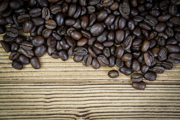 Fresh coffee beans on  wooden table background.