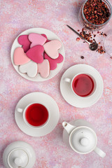 Obraz na płótnie Canvas Heart shape cookies with icing with berry tea. Concept: Valentine's Day tea party, festive table setting in pink.