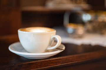 Single cup of cappuccino coffee on bar with blurred background 