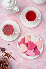 Heart shape cookies with icing with berry tea. Concept: Valentine's Day tea party, festive table setting in pink.