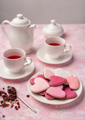 Heart shape cookies with icing with berry tea. Concept: Valentine's Day tea party, festive table setting in pink.