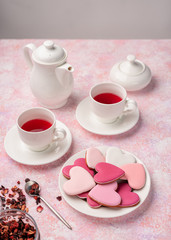 Heart shape cookies with icing with berry tea. Concept: Valentine's Day tea party, festive table setting in pink.