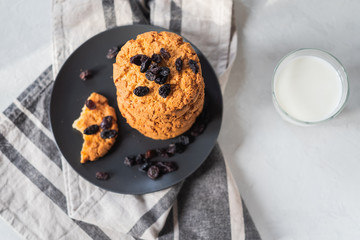 traditional freshly baked chocolate cookies, glass of milk on a grey background close-up. quick snack