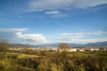 Fototapeta premium Sunrise and sunset, beautiful clouds over the meadow, hills and buildings in the town. Slovakia