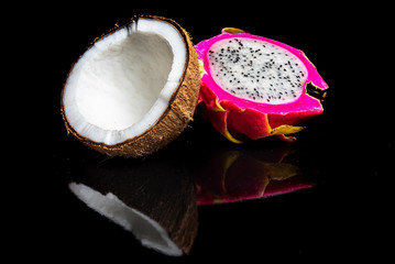 Arrangement with fruits on a shiny black surface with black background.