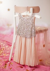 Stock Photo - Child dress on hanger on pink background
