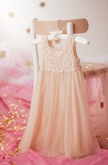 Stock Photo - Child dress on hanger on pink background