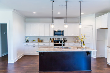 New construction modern kitchen with white cabinets and hardwood floors - obrazy, fototapety, plakaty