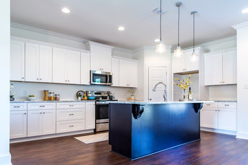 New construction modern kitchen with white cabinets and hardwood floors