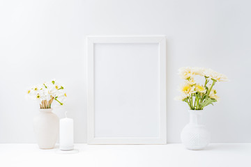Home interior with decor elements. Mockup with a white frame and flowers in a vase on a light background