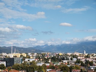 Sunrise and sunset, beautiful clouds over the meadow, hills and buildings in the town. Slovakia