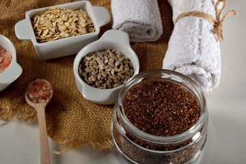 jar full of linseed in the company of other seeds for the production of homemade body cosmetics