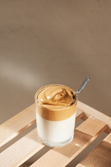 Dalgon coffee with a spoon in the sunlight on a wooden bench