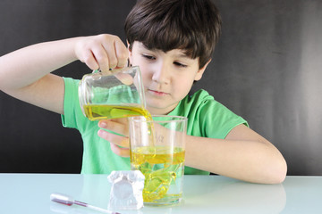 Niño realizando un experimento casero durante la cuarentena por coronavirus, es una lámpara de...