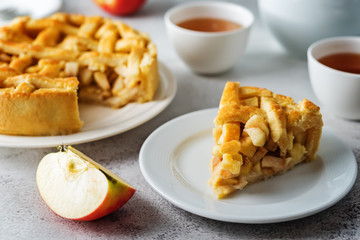 Apple cake with fresh apple slices and cups of tea