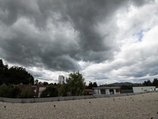 Fototapeta premium Sunrise and sunset, beautiful clouds over the meadow, hills and buildings in the town. Slovakia