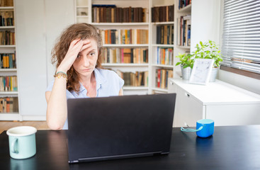 happy woman working on laptop in home office