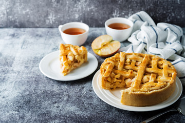 Apple cake with fresh apple slices and cups of tea