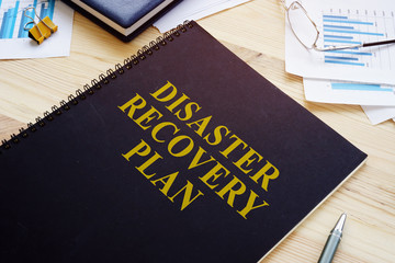 Disaster recovery plan book and stack of papers.