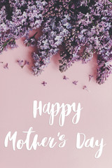 Happy Mother's day text and lilac flowers border on pink paper, stylish floral flat lay. Happy mothers day greeting card