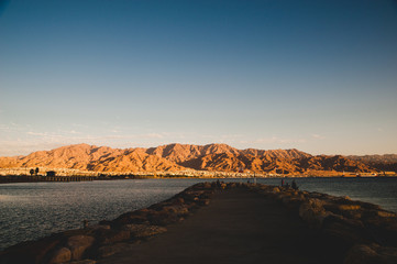 Background of the Jordan mountains. View of Jordan from the beach in Eilat. Sunset in Israel.