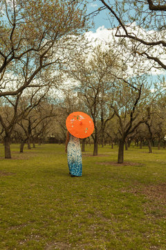 Woman With Umbrella Backwards Between Trees