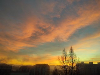 Sunrise and sunset, beautiful clouds over the meadow, hills and buildings in the town. Slovakia