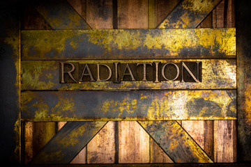 Photo of real authentic typeset letters forming Radiation text on vintage textured grunge copper background