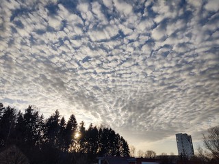 Sunrise and sunset, beautiful clouds over the meadow, hills and buildings in the town. Slovakia