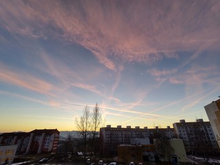 Fototapeta premium Sunrise and sunset, beautiful clouds over the meadow, hills and buildings in the town. Slovakia