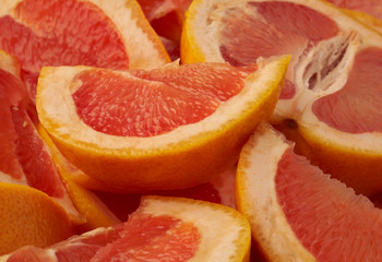 Naklejka na ściany i meble Grapefruit web banner background. Pile of fresh cut grapefruits. Fruits summer bright concept