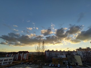 Fototapeta premium Sunrise and sunset, beautiful clouds over the meadow, hills and buildings in the town. Slovakia
