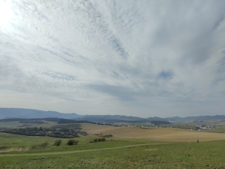 Sunrise and sunset, beautiful clouds over the meadow, hills and buildings in the town. Slovakia