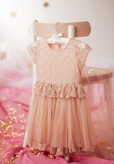 Stock Photo - Child dress on hanger on pink background